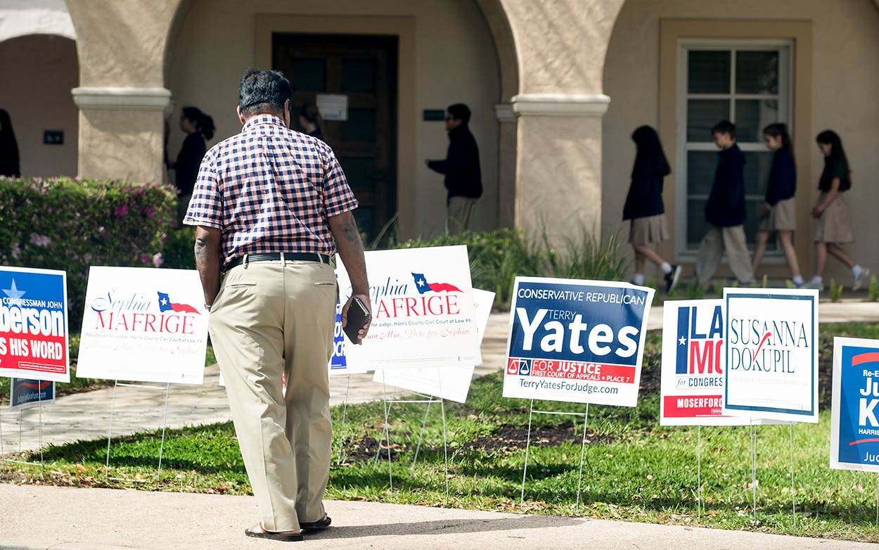 A voter stops to look at primary election signs outside the polling place at St. Anne's Catholic Church on Tuesday, March 6, 2018, in Houston.