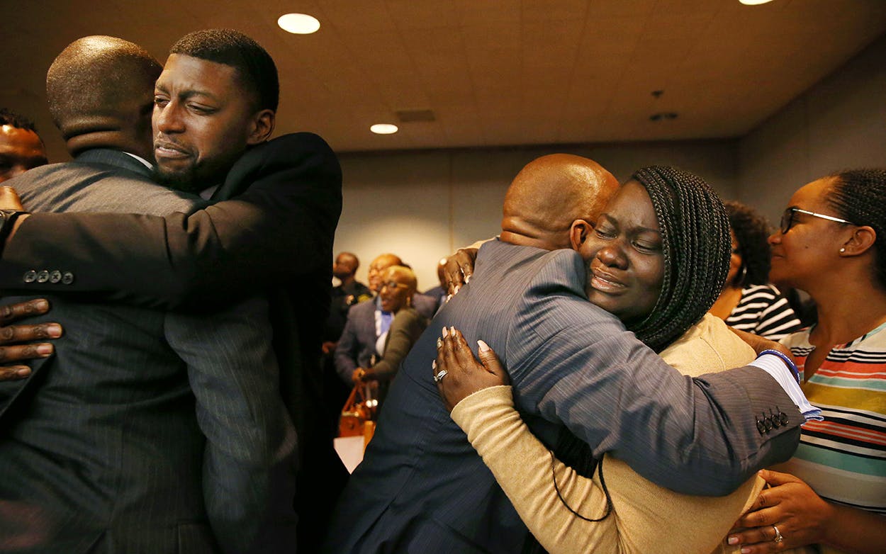 Parents of Jordan Edwards, Odell and Charmaine Edwards (facing camera), hug prosecutor George Lewis (L) and family member Reggie Edwards (R), as they react to a guilty of murder verdict during the ninth day of the trial of fired Balch Springs police officer Roy Oliver, who was charged with the murder of 15-year-old Jordan Edwards, on August 28, 2018 in Dallas.