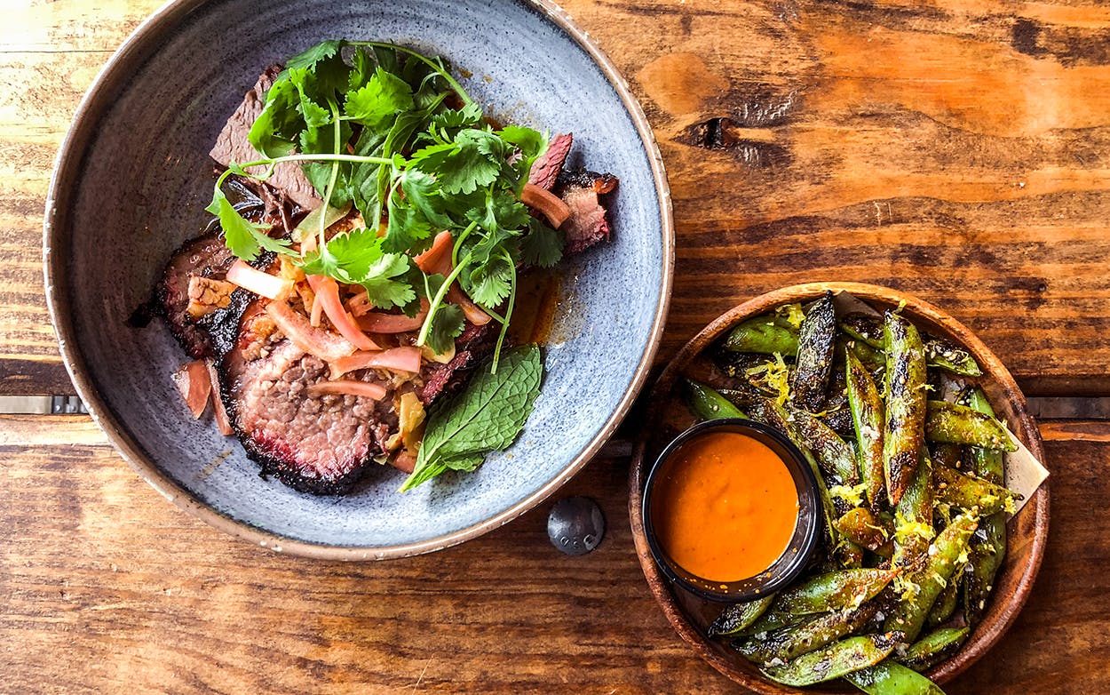 Sliced brisket and grilled snap peas at Loro