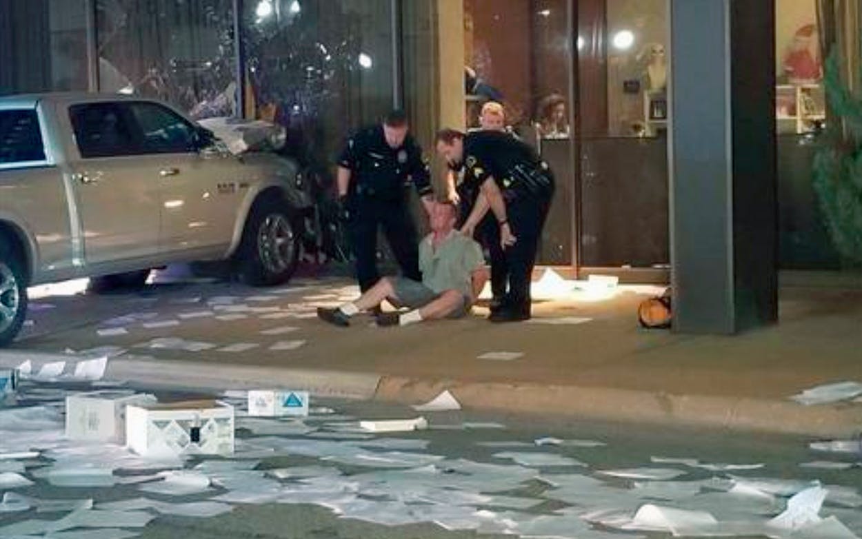 In this image taken from video by KDFW Fox 4 a man is detained after crashing his pickup truck into the side of the Fox affiliate television station building in downtown Dallas on Wednesday, Sept. 5, 2018.