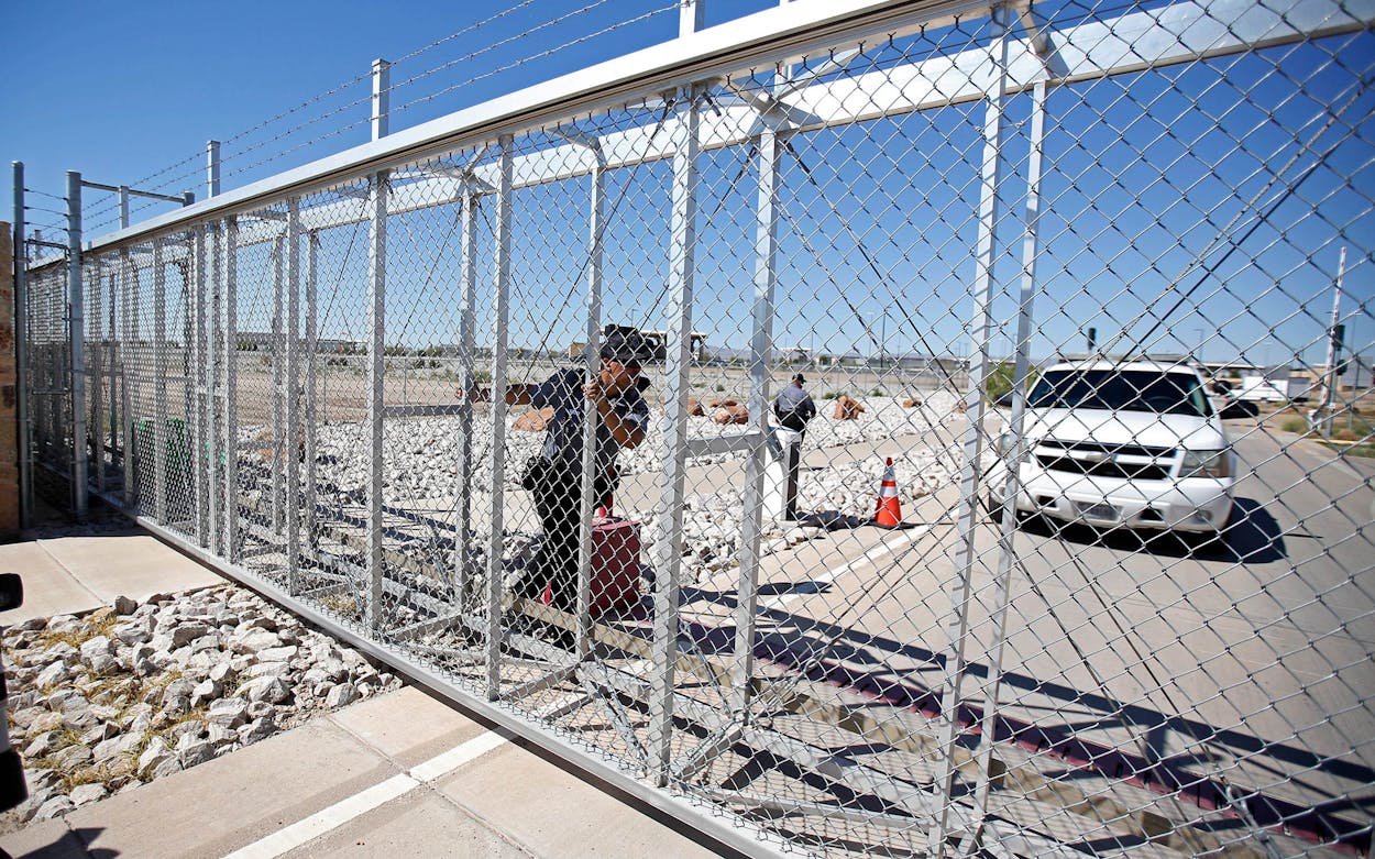 An agent with the Department of Homeland Security closes the exterior gate of the holding facility for immigrant children in Tornillo, Texas, near the Mexican border, Thursday, June 21, 2018.
