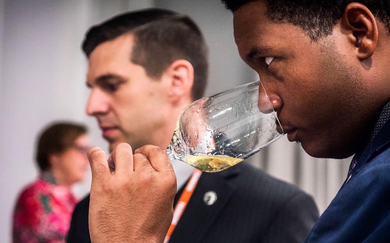 An attendee tastes a glass of wine at TEXSOM.
