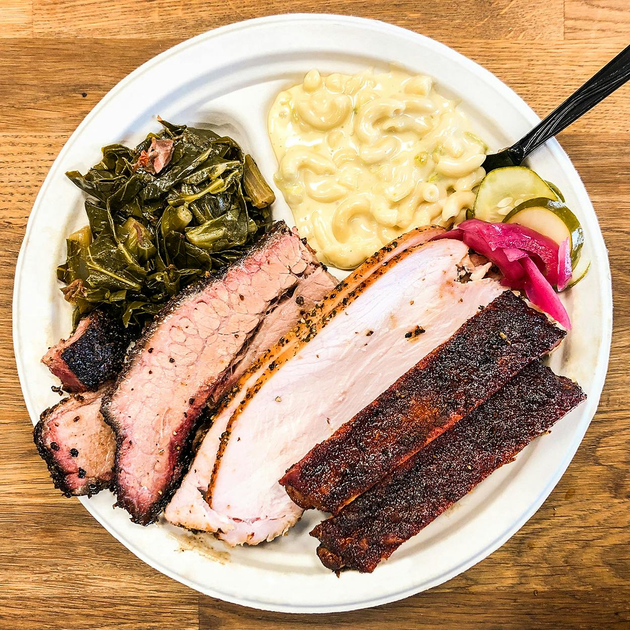 three meat bbq plate with macaroni and cheese and collard greens