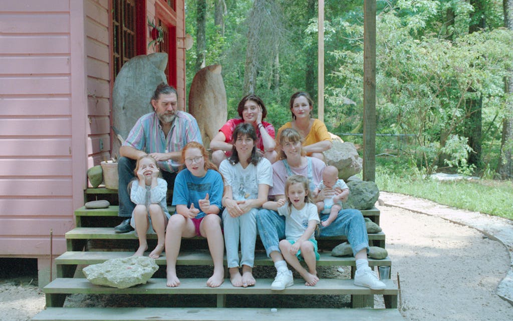 Top row (left to right): James Surls, Abbie Sporl, Charmaine Locke; second row (left to right): Lily Surls, Ruby Surls, ShawnTay Surls, Shannon Surls holding baby Molly Surls; Bottom row: Eva Surls. Taken on the steps of the Locke/Surls house, in Splendora in 1990.