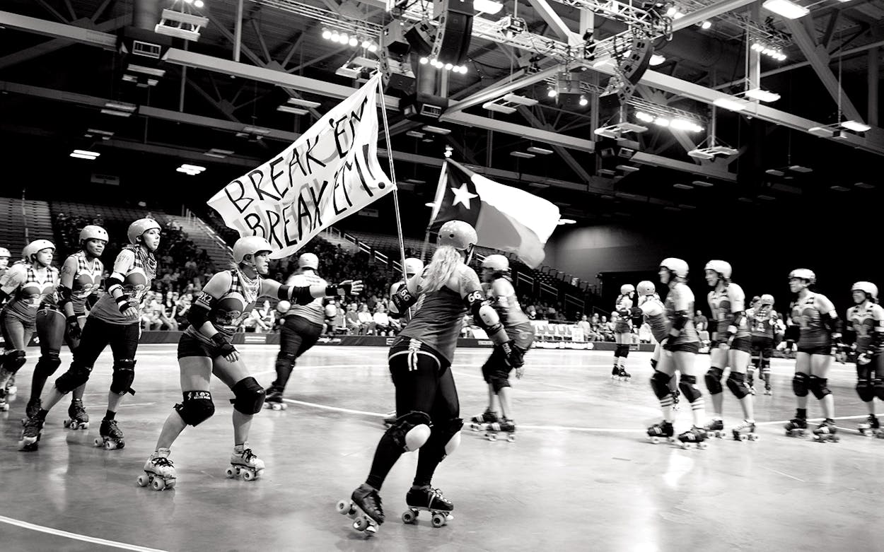 Roller derby team the Honky Tonk heartbreakers carry flags around the track