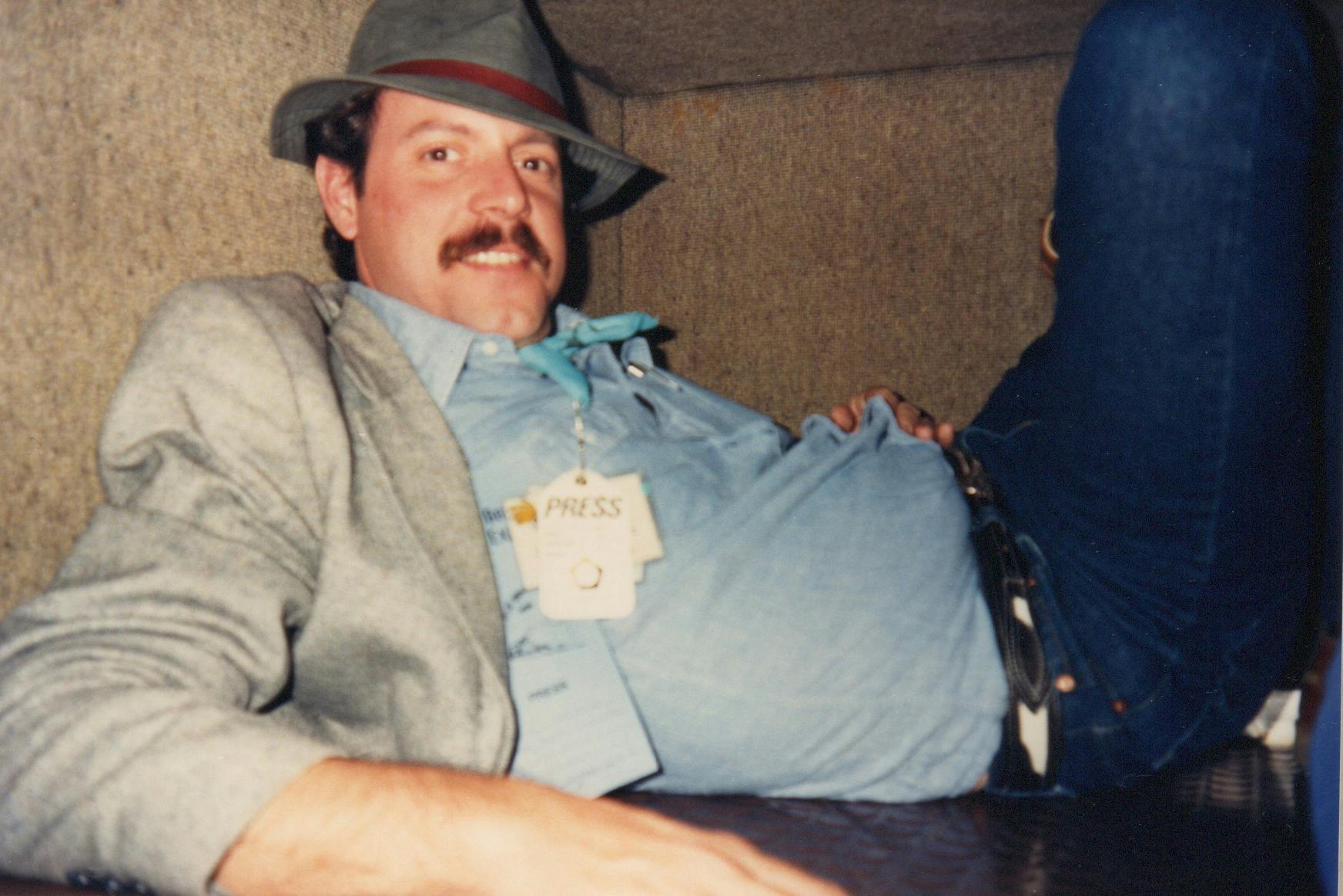 R.G. Ratcliffe hanging out in the luggage compartment of a train during the 1988 Michael Dukakis campaign for president.