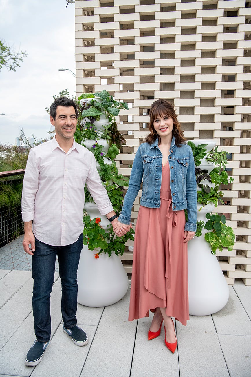 Zooey Deschanel and her husband Jacob Pechenik in front of a couple of Lettuce Grow’s “Farms.”