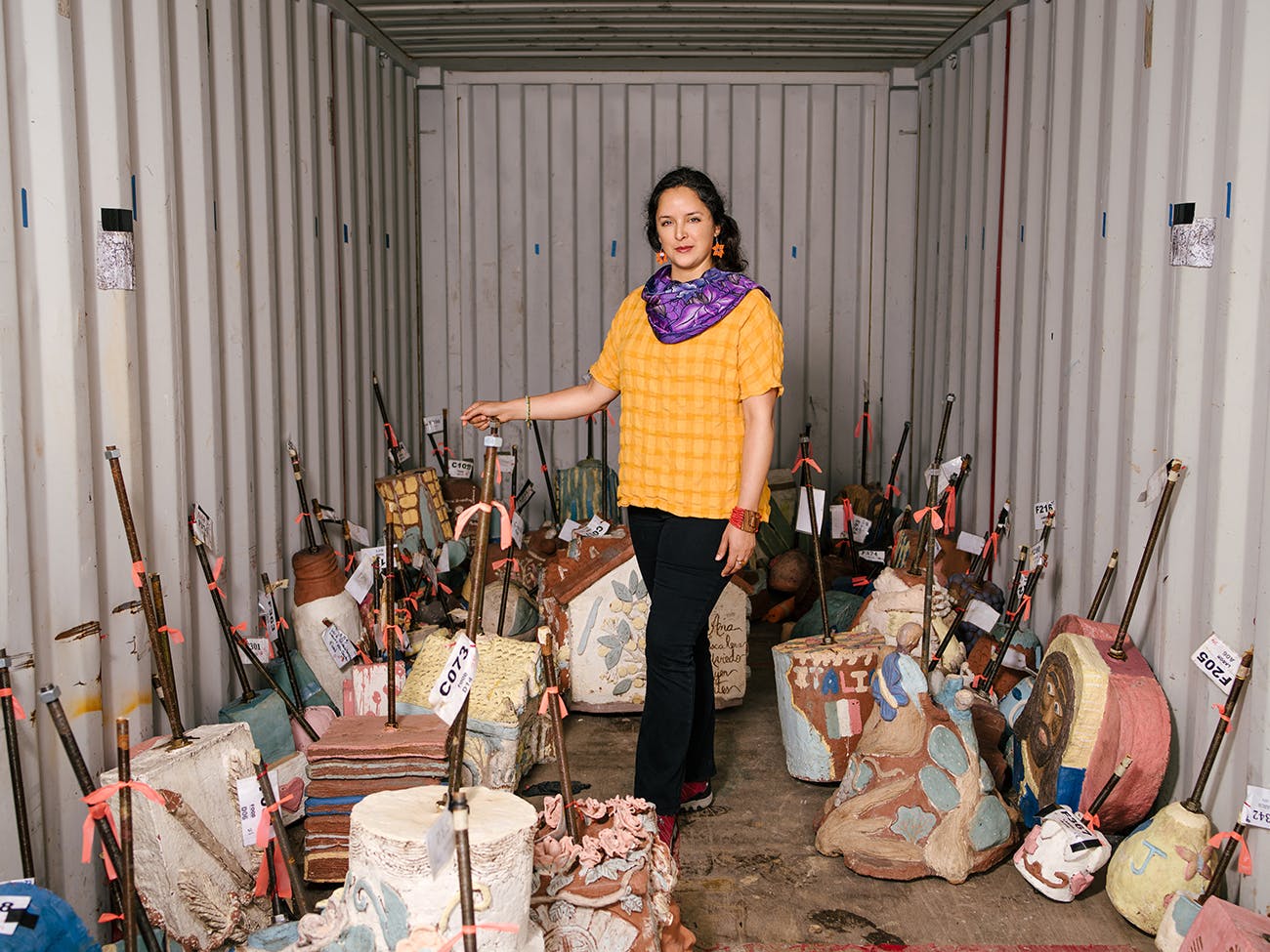 Cabrera in a storage unit containing sculptures that are to be hung.