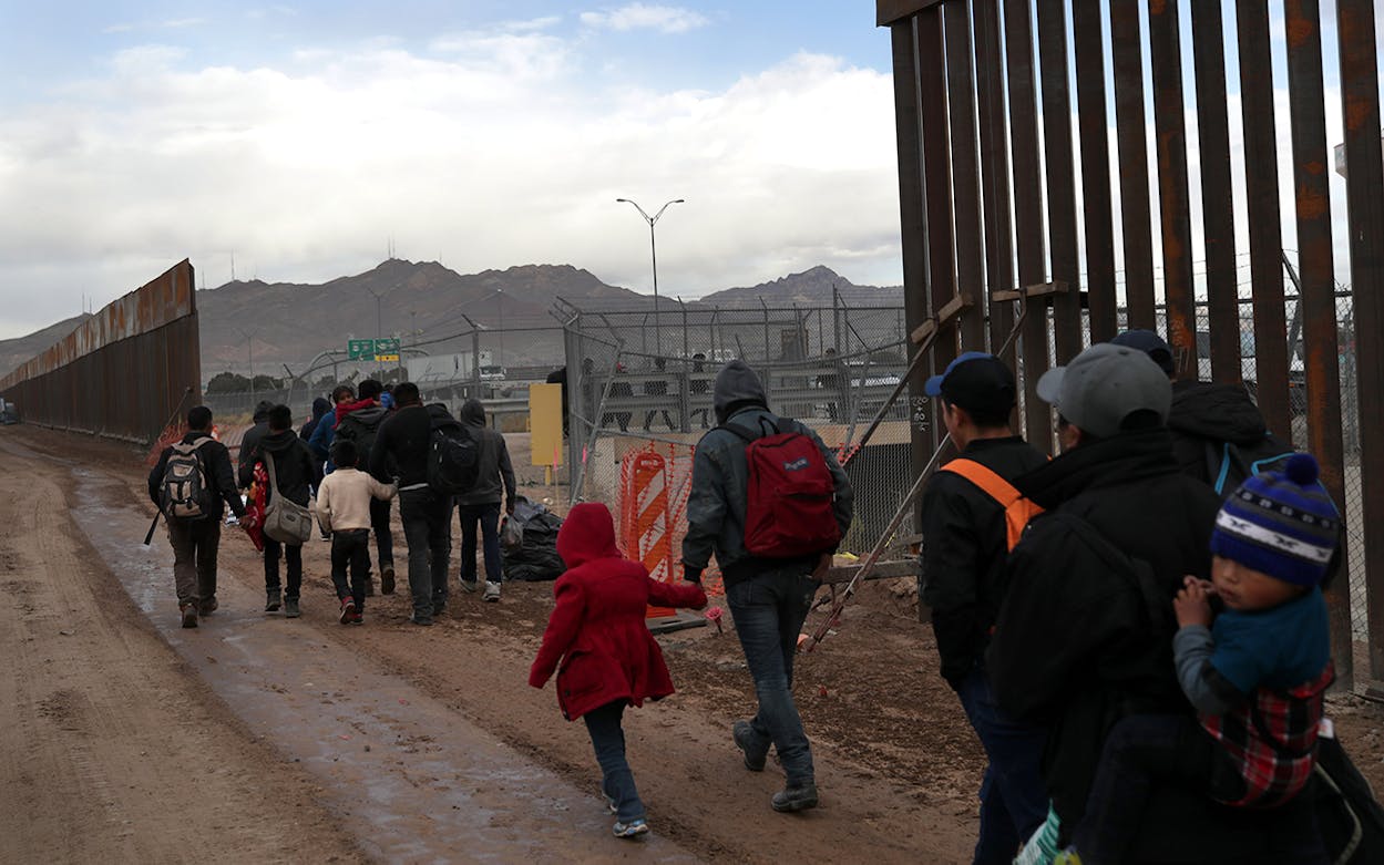 Central American immigrants walk between a gap in the border fence after crossing the Rio Grande from Mexico on February 01, 2019 in El Paso, Texas. The migrants turned themselves in to U.S. Border Patrol agents, seeking political asylum in the United States.