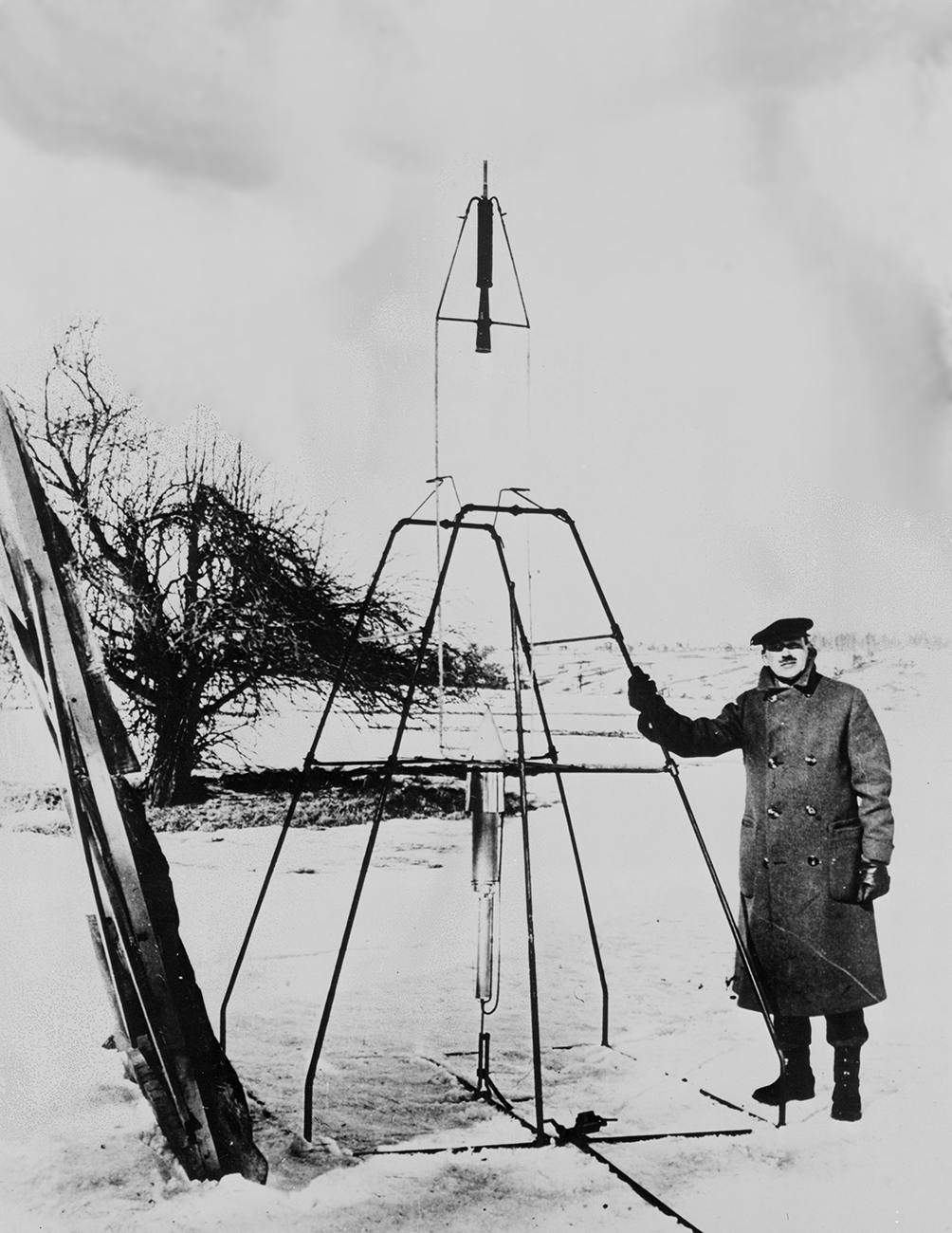 Dr. Robert H. Goddard and his liquid-fueled rocket in the frame from which it was fired on March 16, 1926, at Auburn, Mass.
