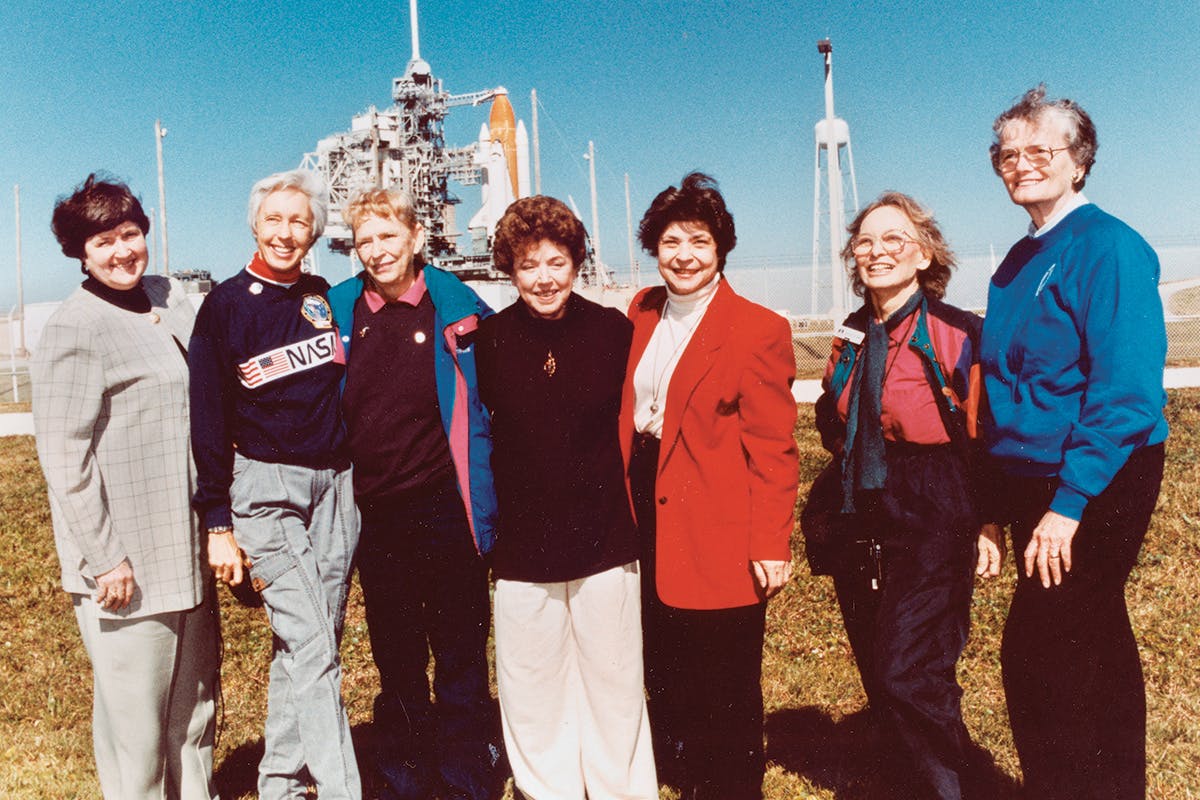 Wally Funk with other member of the Mercury Thirteen, older now, in front of a space shuttle.
