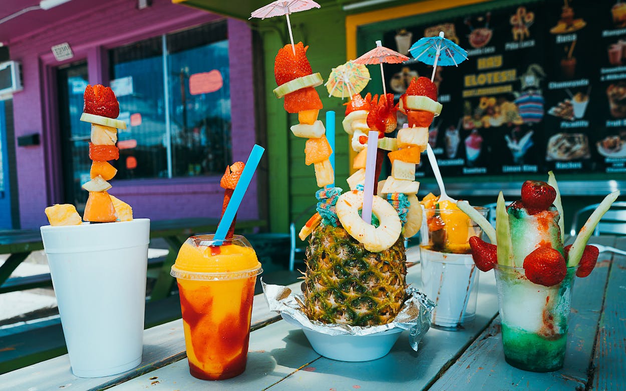 A collection of raspas adorned with fruit and candy.