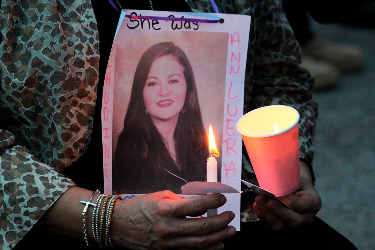 A family member holds a photo of Claudine Luera during a prayer vigil .