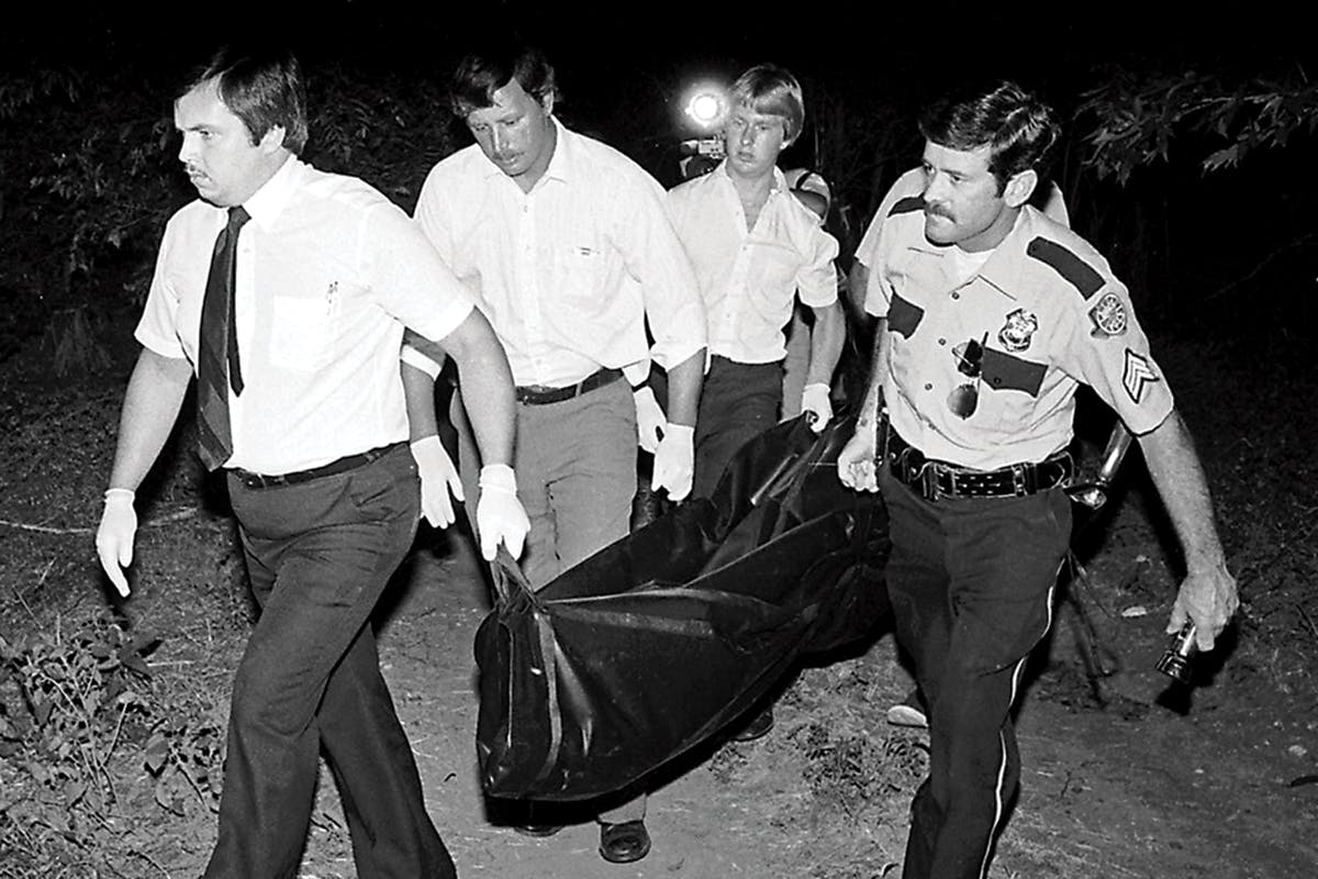 Truman Simons, investigator in the Waco Murders, helping carry the bodies out from the brush. 