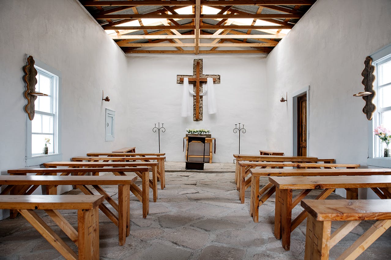 Altar, cross, and pews inside of Calera Chapel.