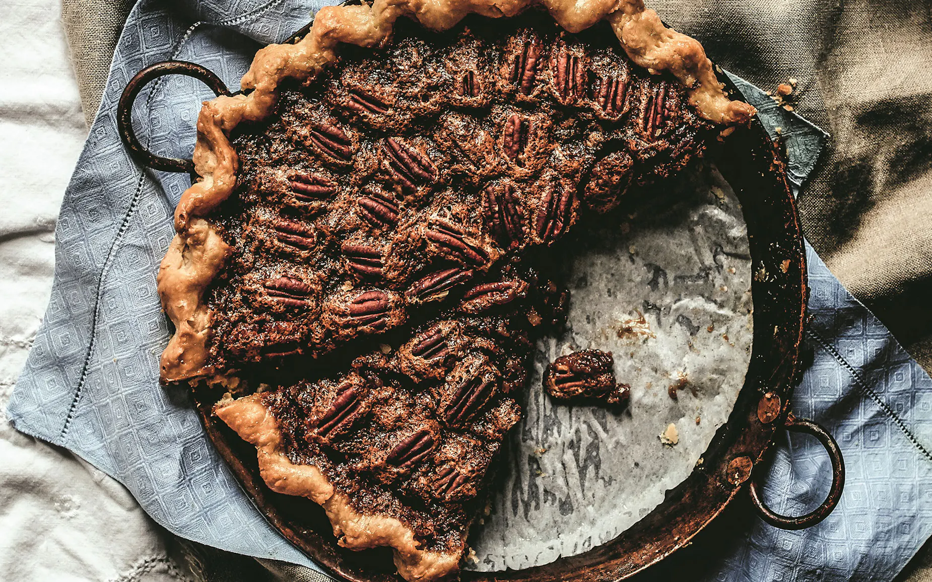 A pecan pie with a few slices taken out of the pan