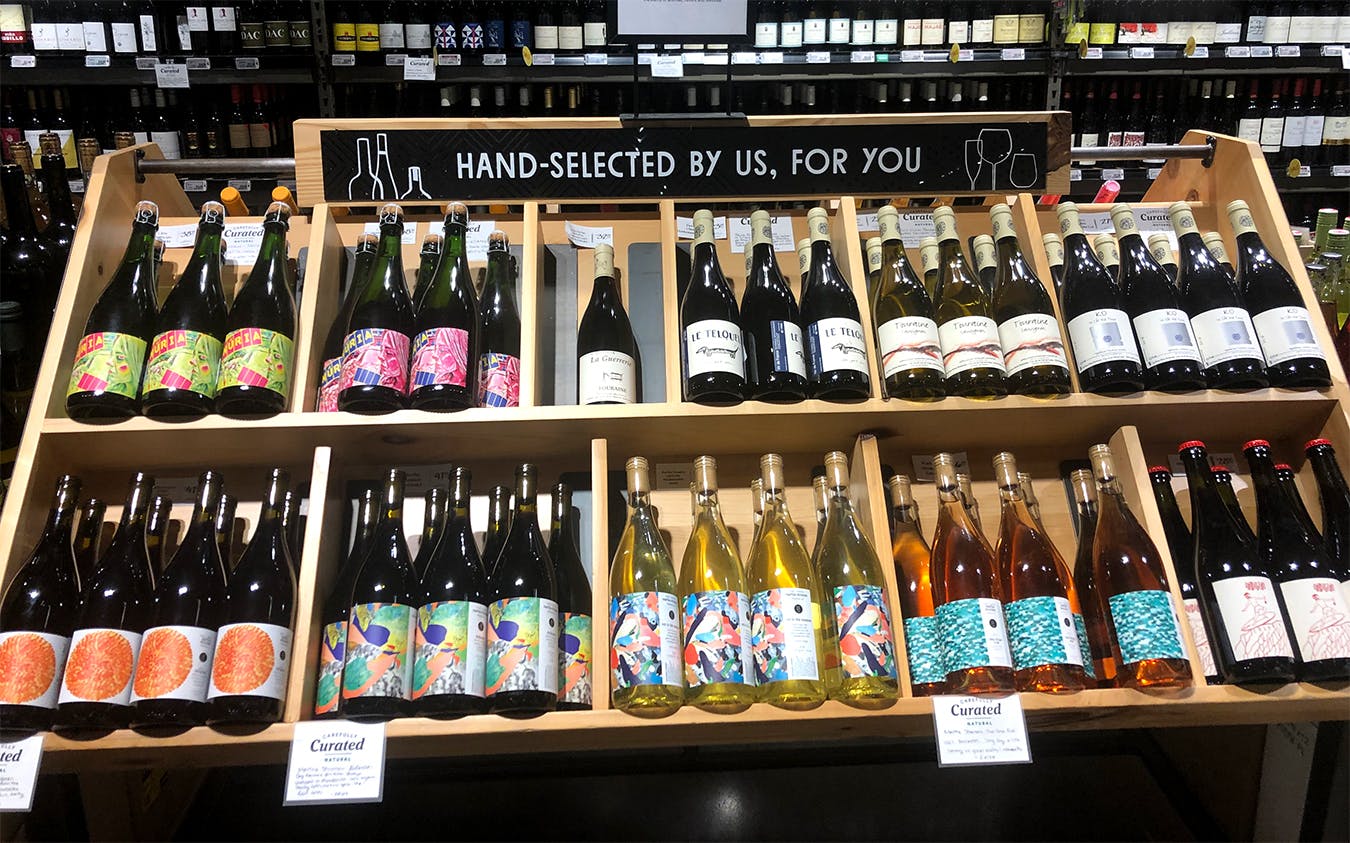 Whole Foods wines organized by type, with a sign reading, "hand selected by us, for you."