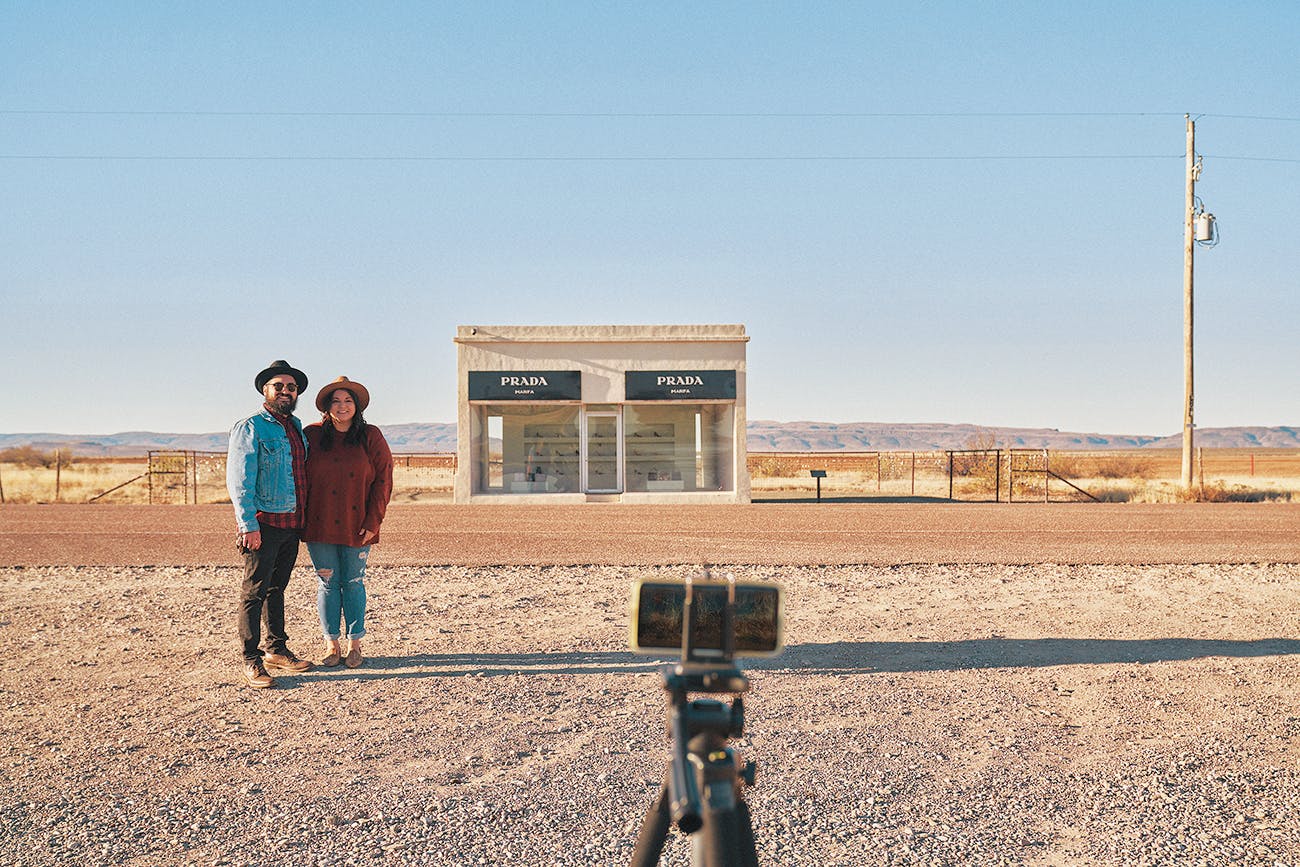 Tourists pose in front of Prada Marfa. 