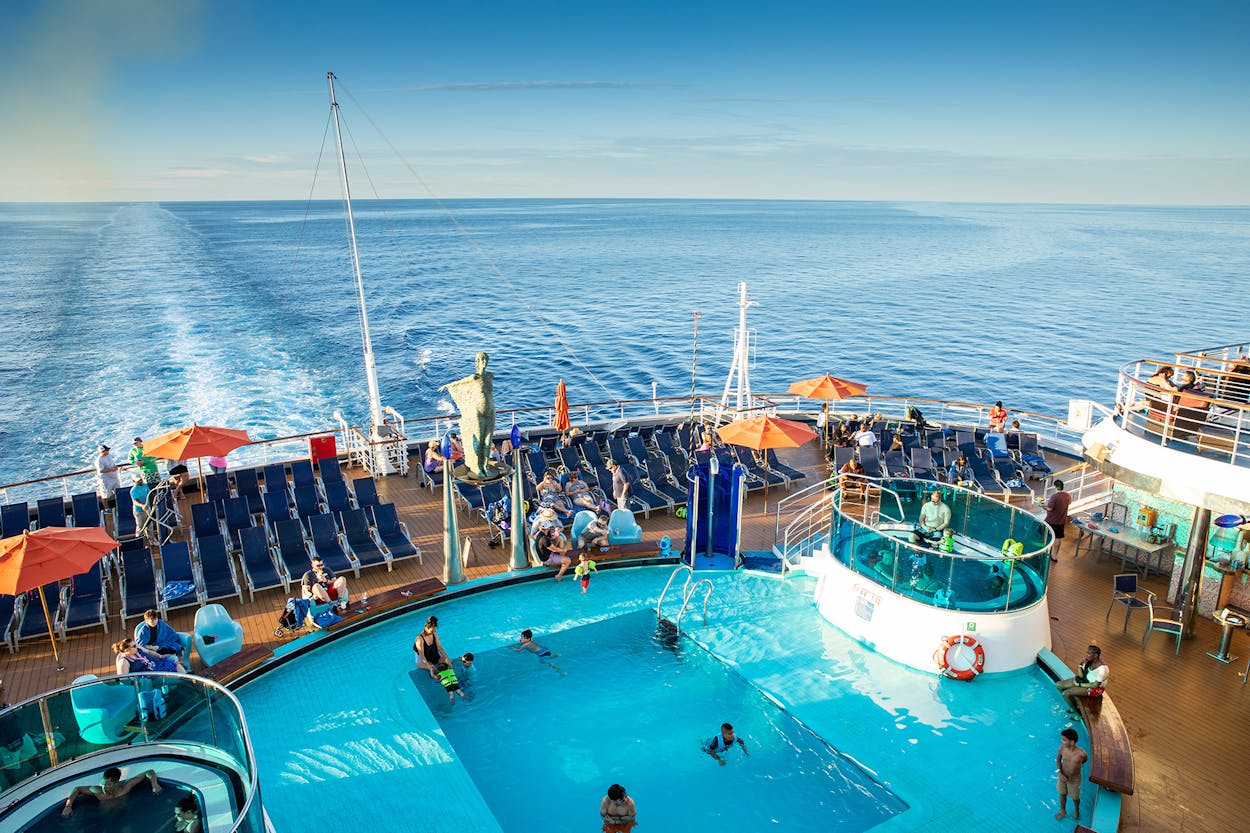 Passengers swim in the carnival cruise ship deck pool