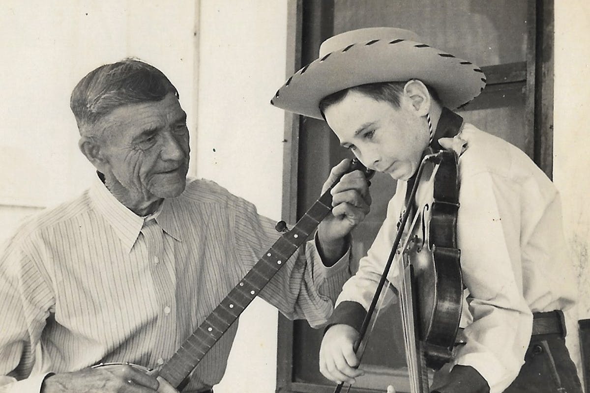 Young Jim Seals playing music with his grandfather
