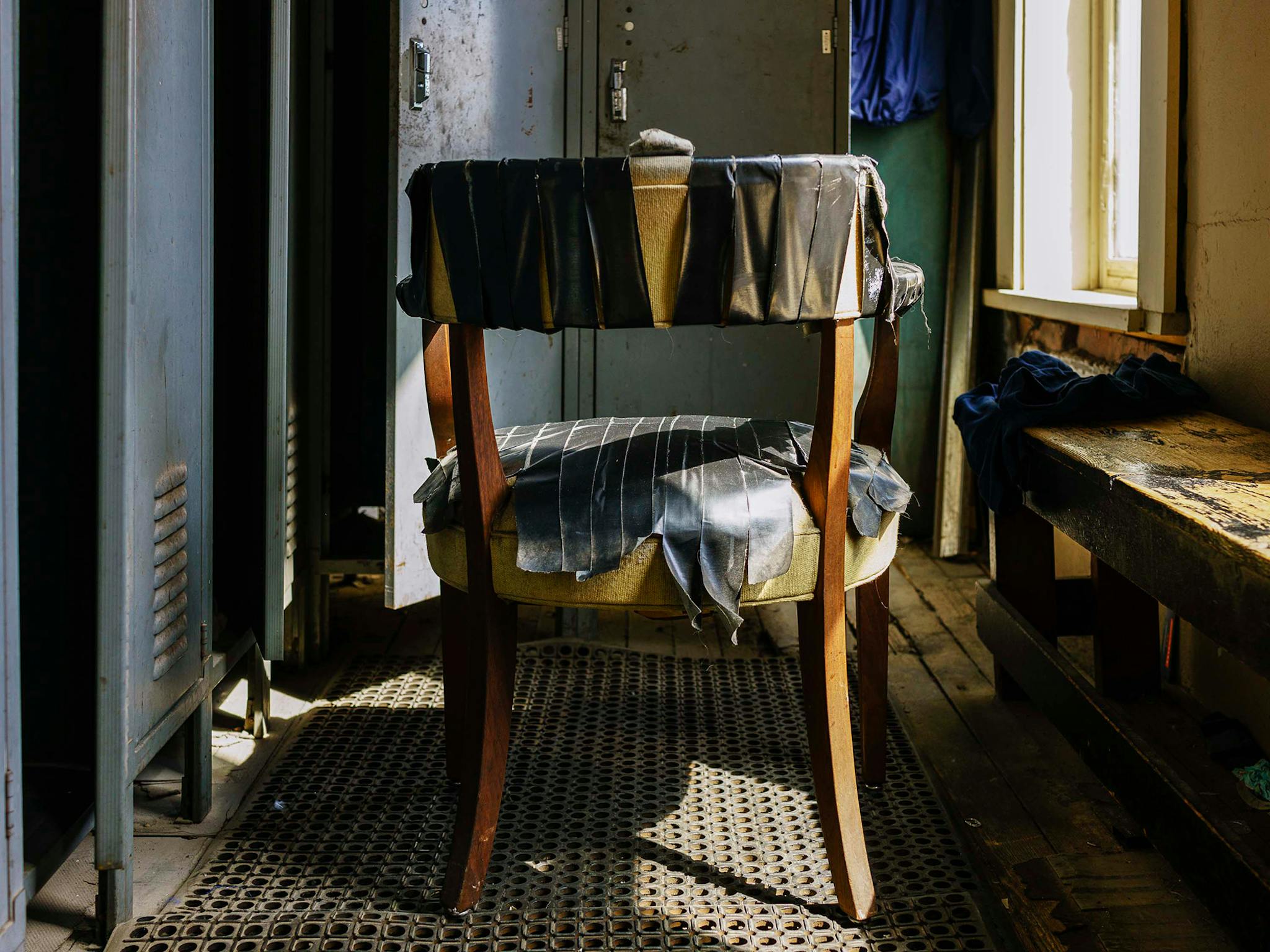 “The dilapidation was pretty striking,” says Diamond. The locker area—populated by a worn bench and this chair held together by yards of duct tape—was no exception. The men’s bathroom, however, was even worse: “I showed my pictures of the men’s room, which was filthy, to my mentor [fine art photographer Cig Harvey], and she felt physical revulsion. She said, ‘You cannot put those in the book.’” (He did not.) There were no doors on the men’s or women’s bathrooms, just flimsy curtains separating them from the rest of the workout area.