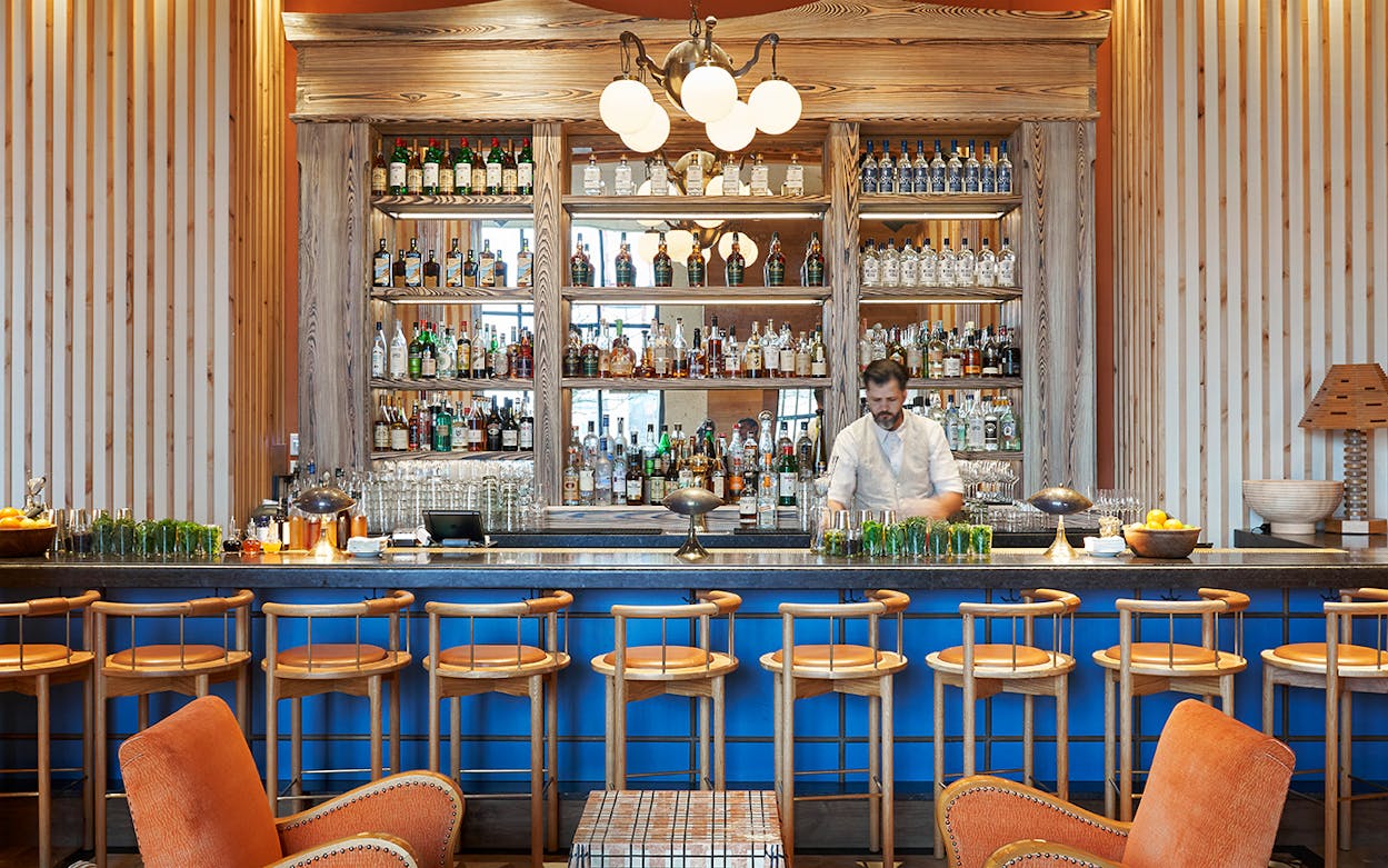 Blue bar with gold shelving at Austin Proper Hotel.
