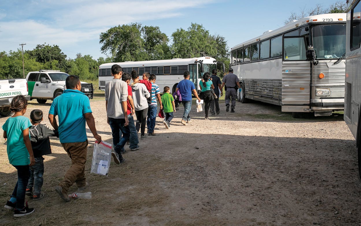 Immigrants walk to U.S. Homeland Security busses to be transferred to a U.S. Border Patrol facility in McAllen after crossing from Mexico on July 2, 2019.