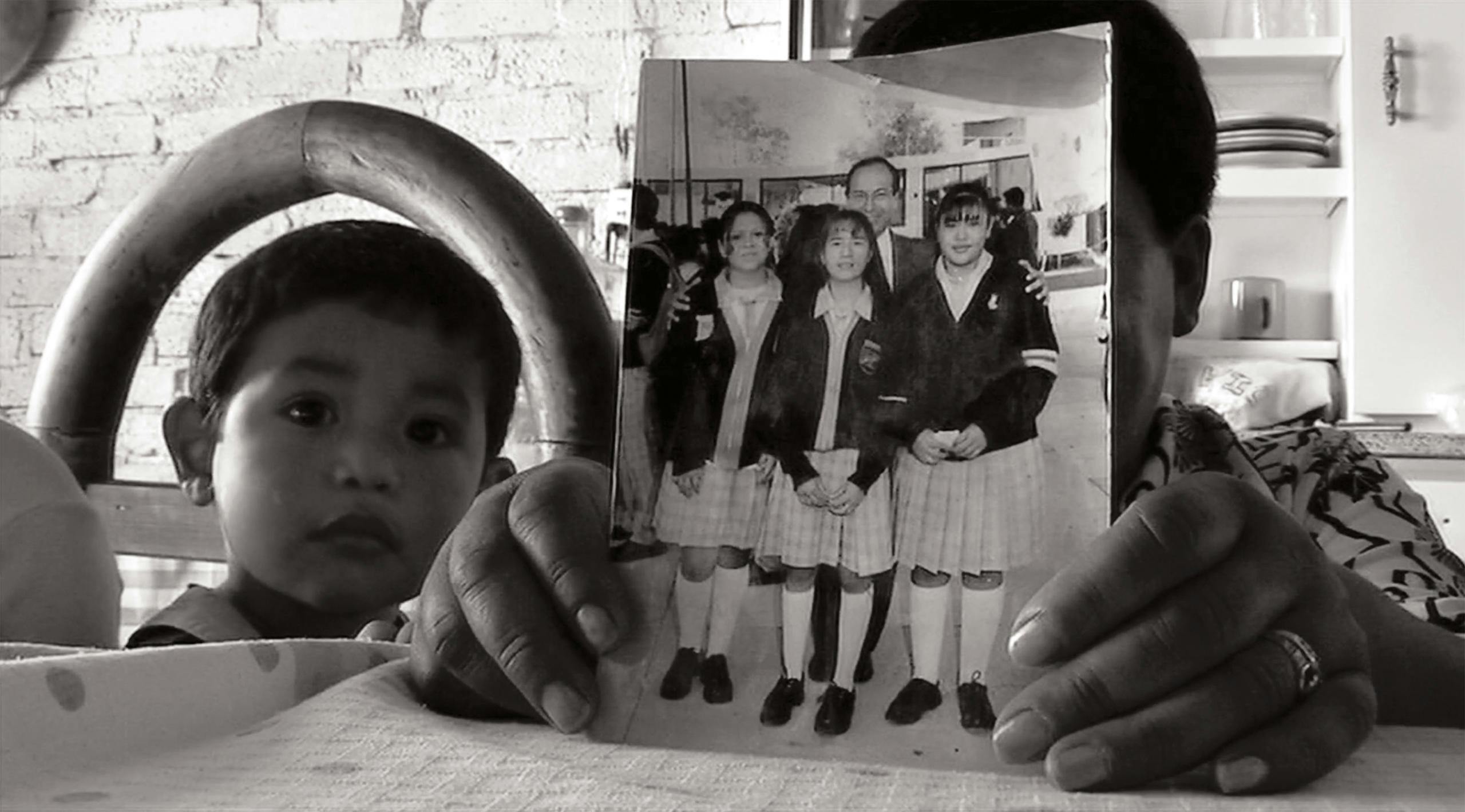 In a scene from Mi Vida Dentro, Jimenez’s mother holds a photo of Rosa, on the far right, that she used to show to Jimenez’s kids so they’d remember their mother’s face. Jimenez’s son, Emmanuel, looks on at left.