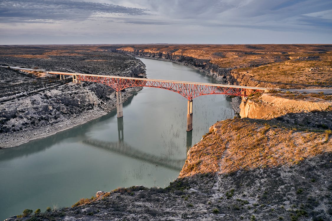 Landscape shot of a bridge stretching over the Pecos River. 