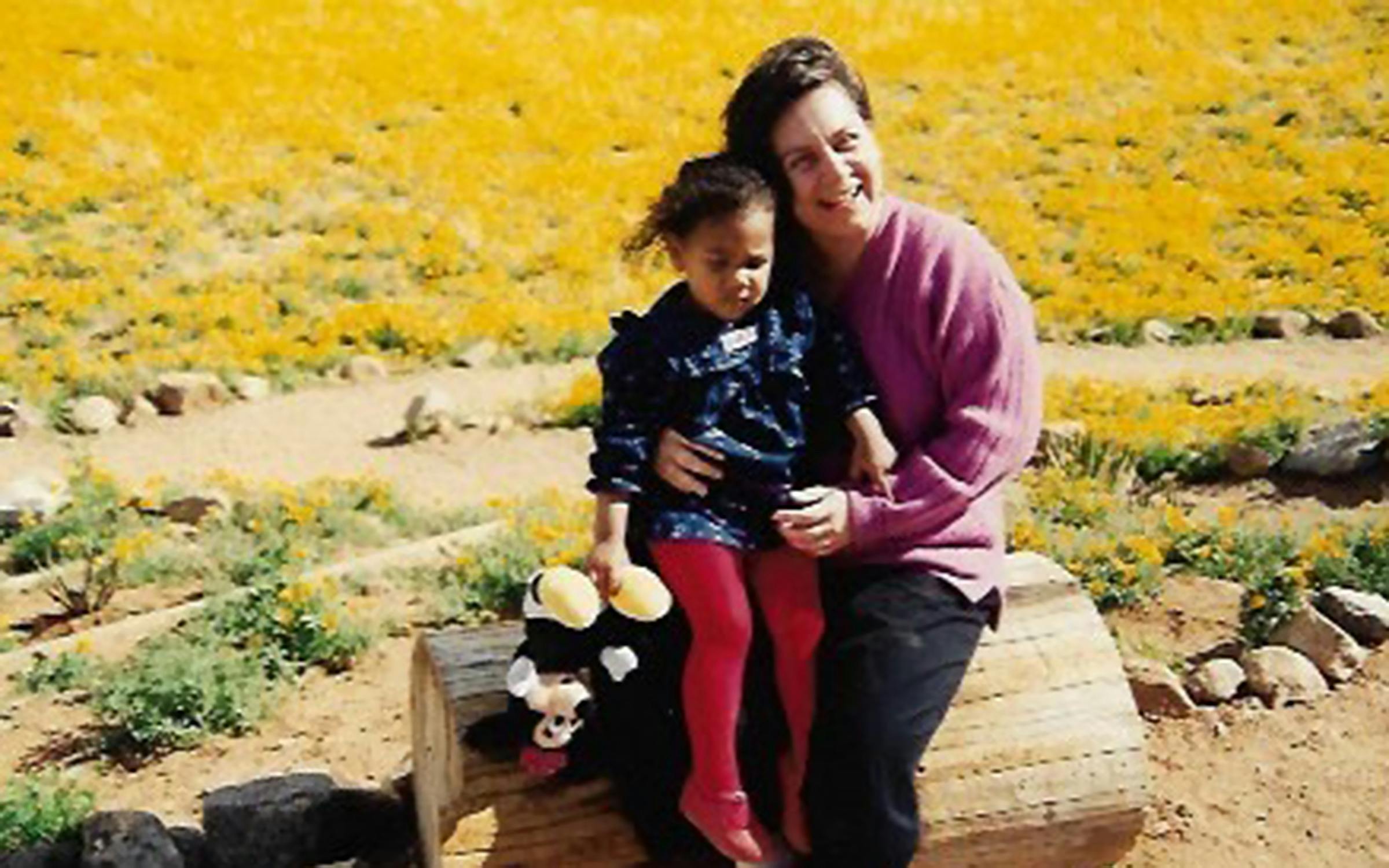 The author as a toddler and her mother in a field of yellow wildflowers. 