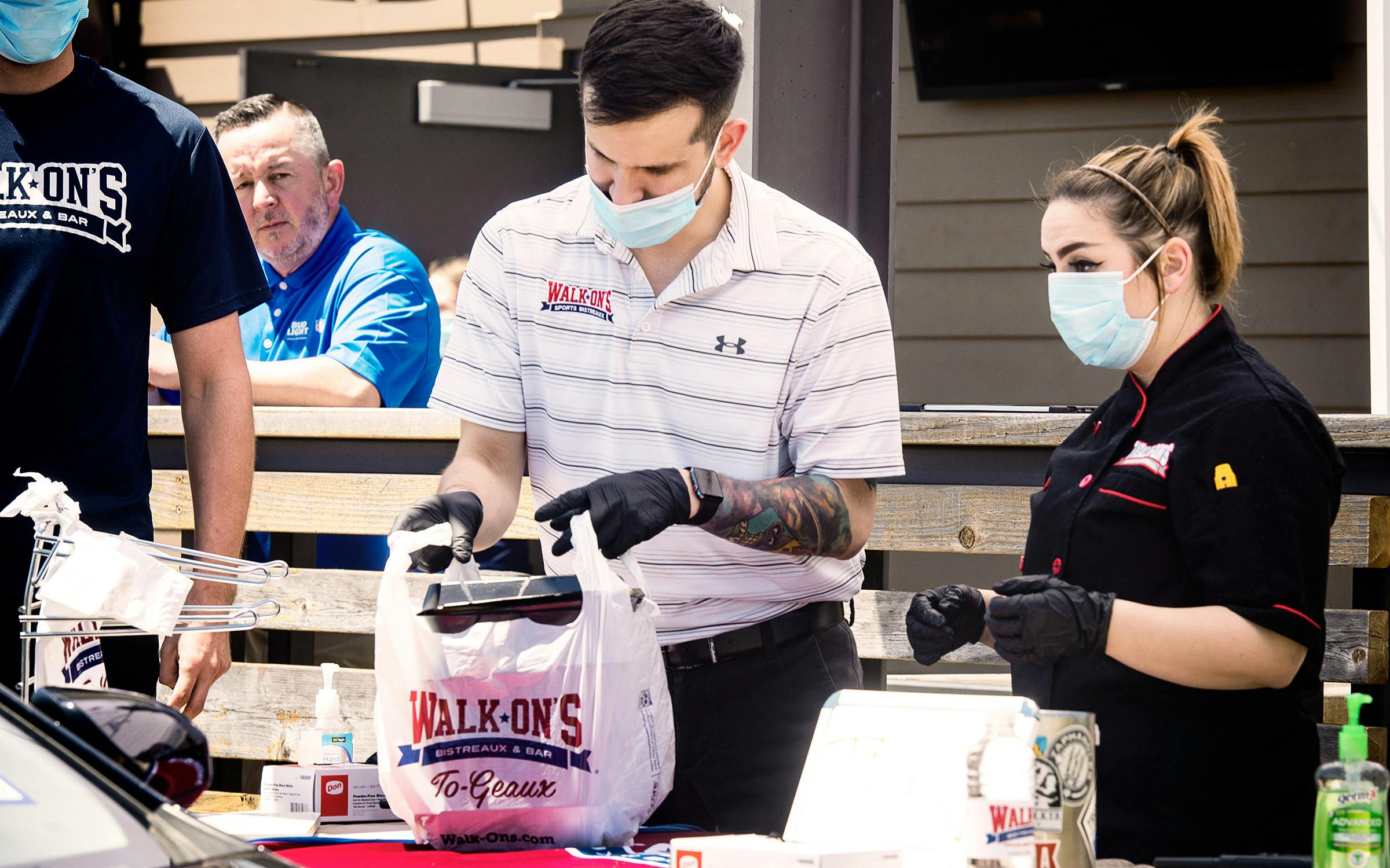 Walk-On's Sports Bistreaux general manager Fernando Guzman and executive kitchen manager Presley Parker bag meals to hand out during the restaurant's Furlough Kitchen by Walk-On's event in Tyler on April 30, 2020.