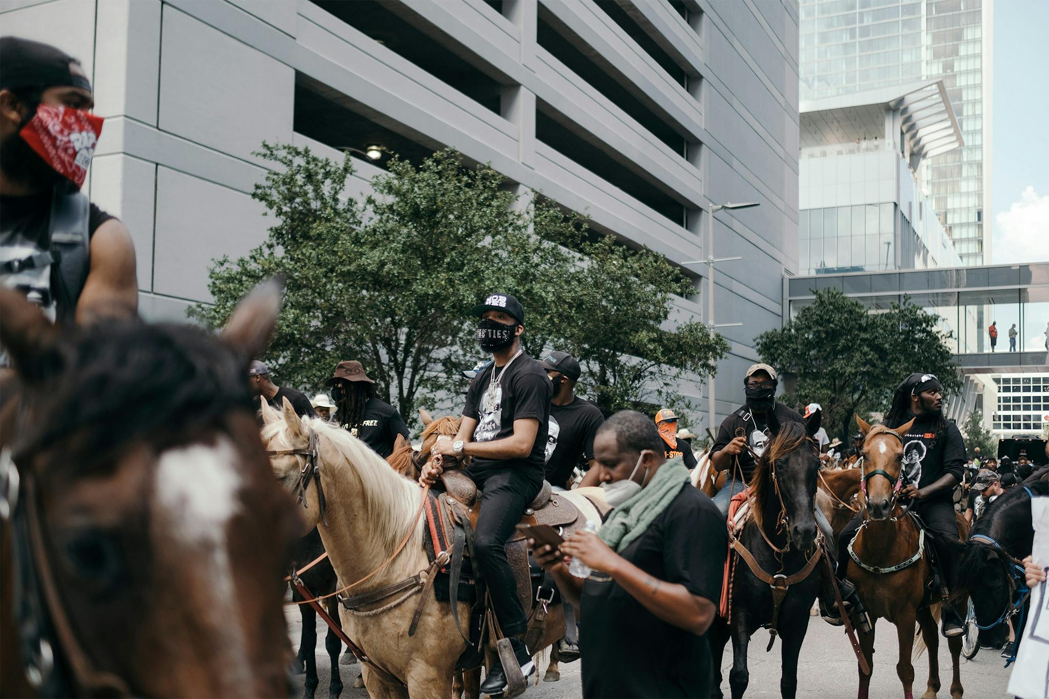 J Prince Jr, center, prepares to ride his horse down Walker street during a march to honor the memory of George Floyd in downtown Houston on June 2, 2020.