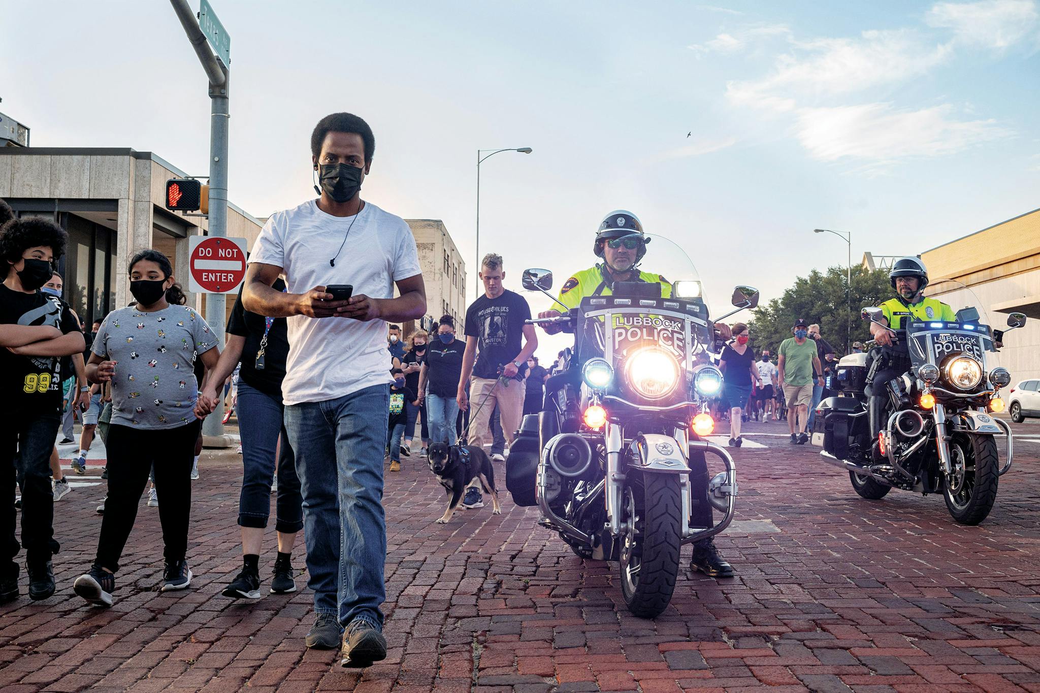 Participants in the 100 Black Men of West Texas solidarity walk are escorted by police officers at 8 p.m. in Lubbock on June 1, 2020.