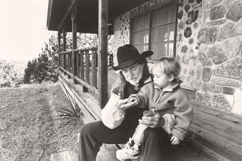 Willie with his son Lukas Autry, two, chatting on the front steps of his cabin.
