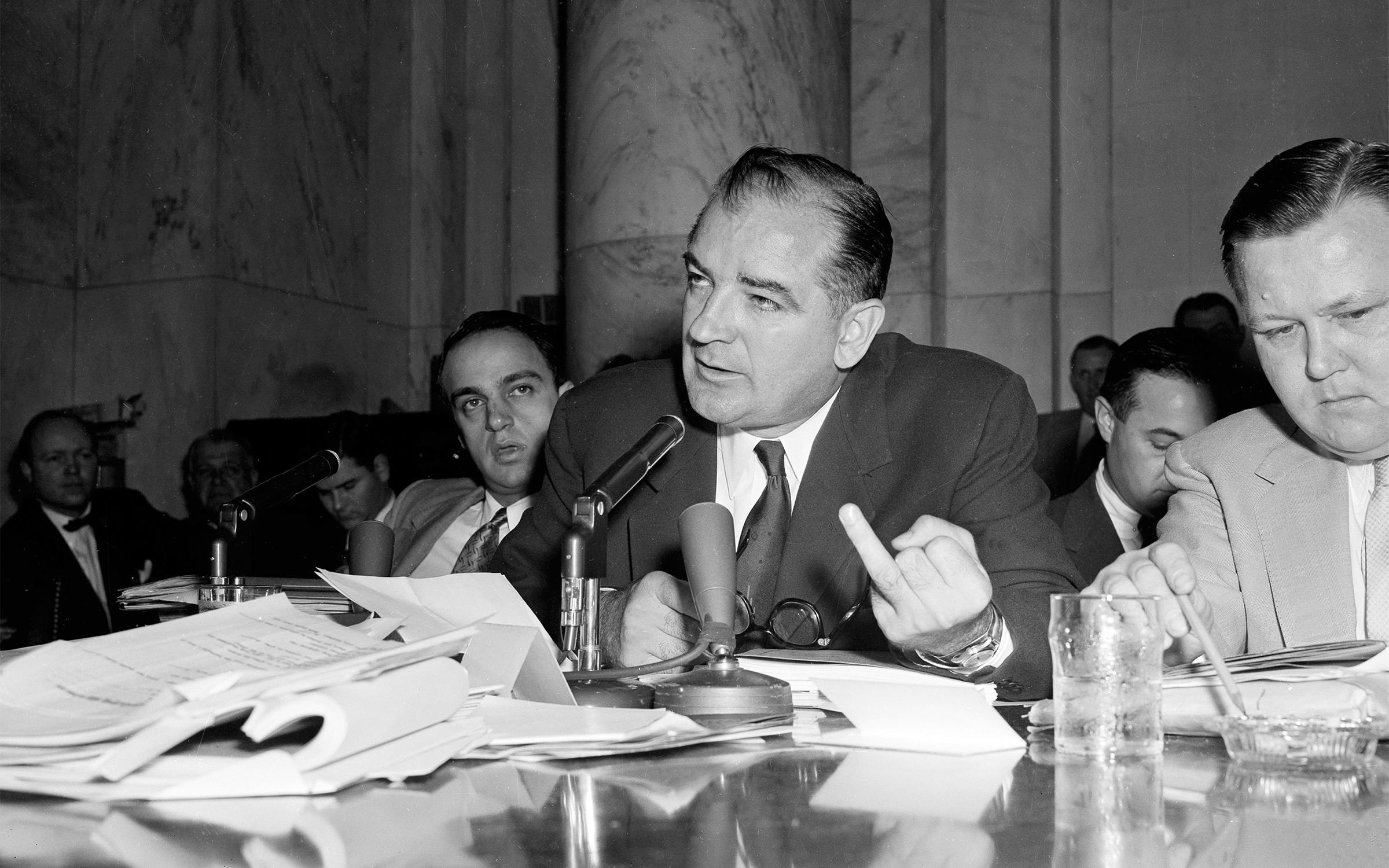 Sen. Joseph McCarthy gestures as he directs a question to Army Secretary Robert Stevens during the afternoon session of the hearings into his differences with high Pentagon officials, in Washington, D.C., on April 28, 1954. McCarthy's aide, Roy Cohn, is at left.