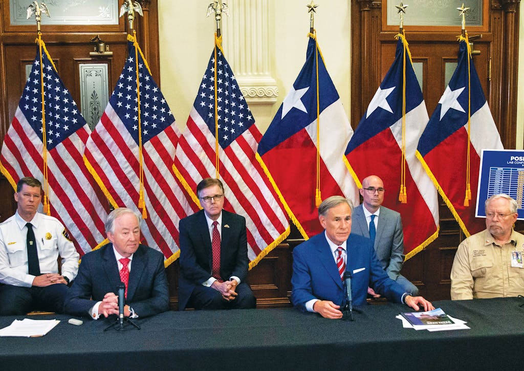 State officials surround Texas governor Greg Abbott (third from right) as he announces the reopening of more Texas businesses at a press conference at the Capitol in Austin on Monday, May 18, 2020.