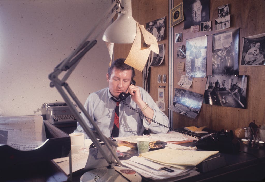 Bud Shrake in an office, on the phone