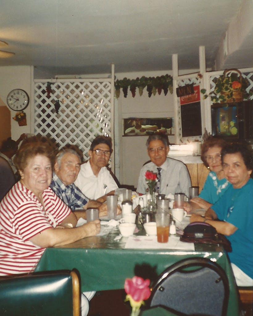 The author's father (head of the table) and aunts and uncles together at a restaurant in Brownsville in 1996.
