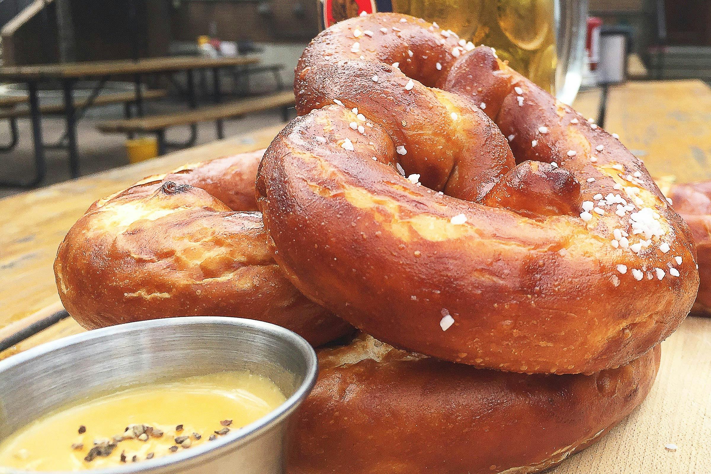 Stack of Scholz Garden's giant Bavarian pretzels with cheese dipping sauce. 