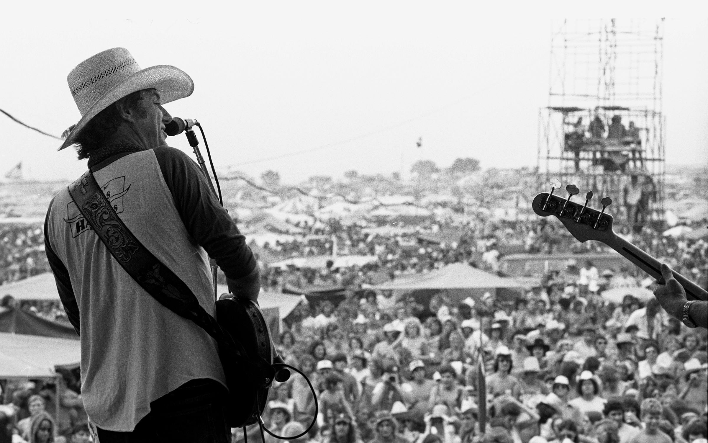 Jerry Jeff Walker performing in front of a large crowd at Willie's 4th of July Picnic. 