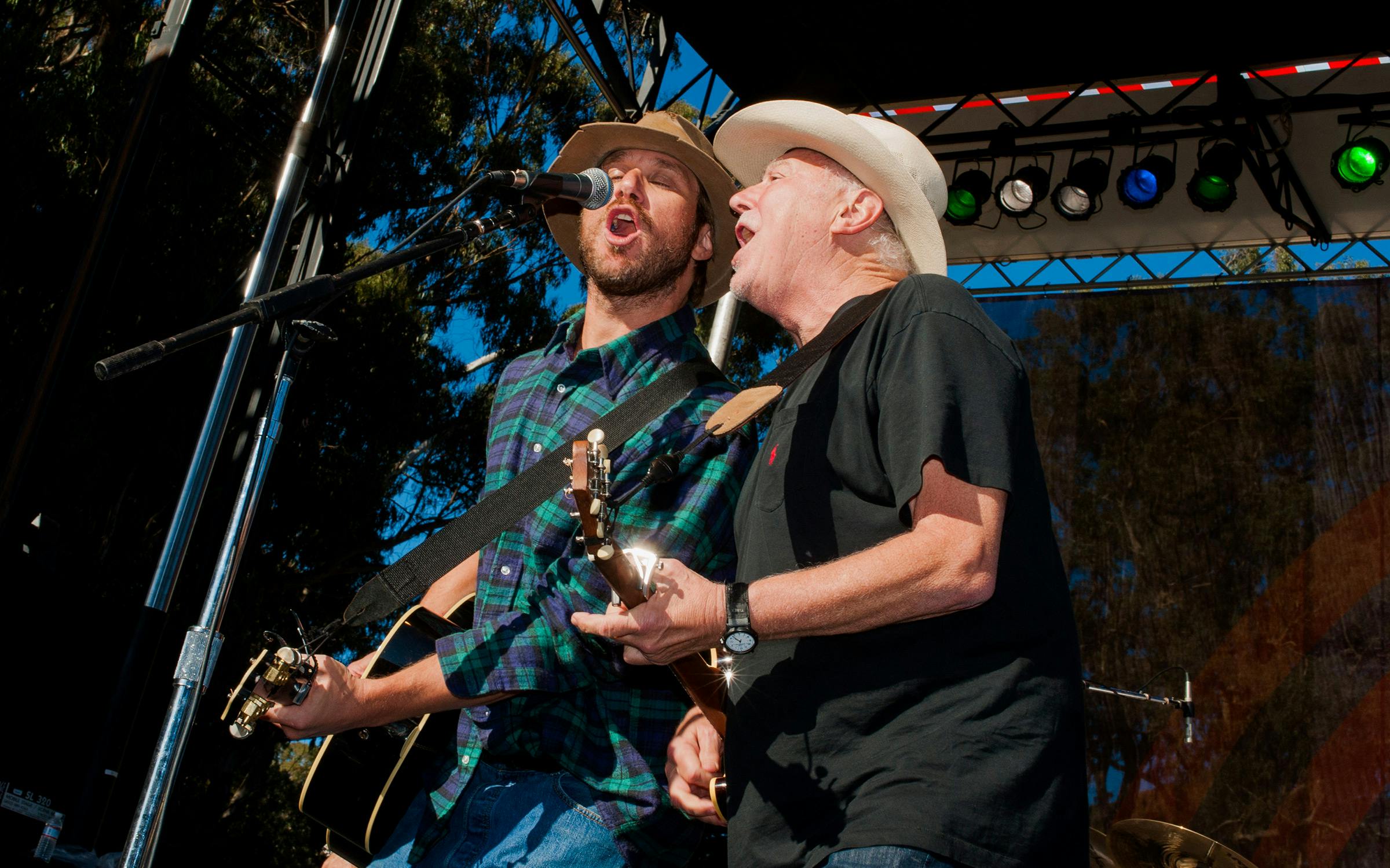 Jerry Jeff Walker and Todd Snider sing into a microphone together. 