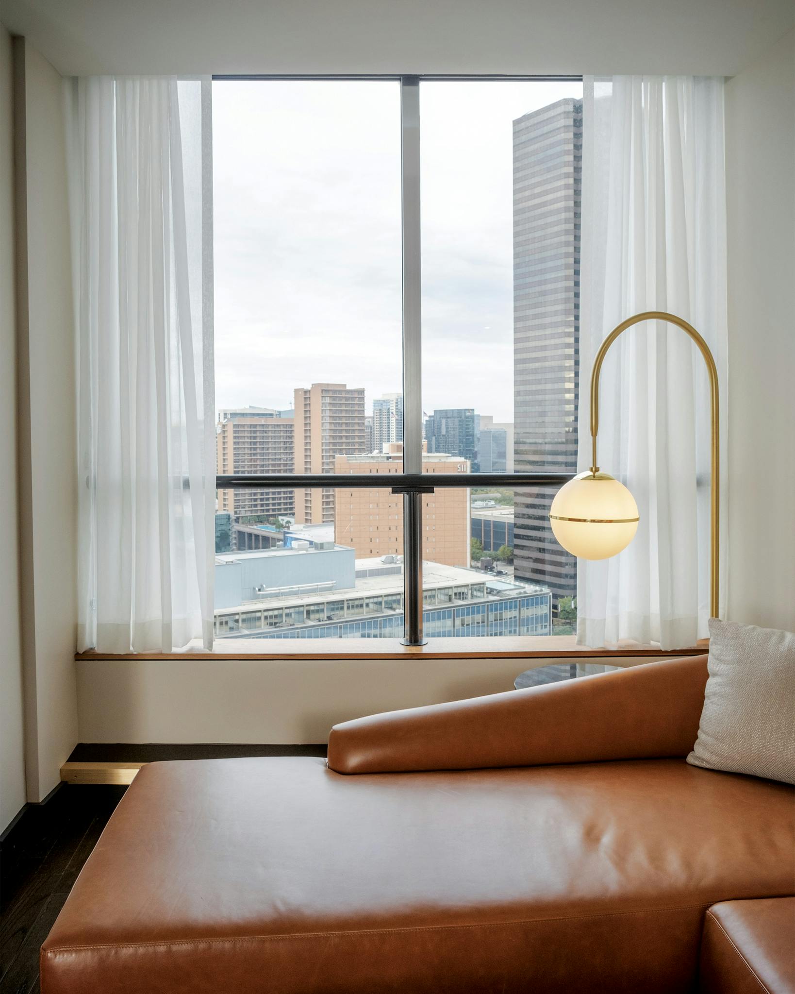 A room with a sitting area and a view of the Dallas skyline.