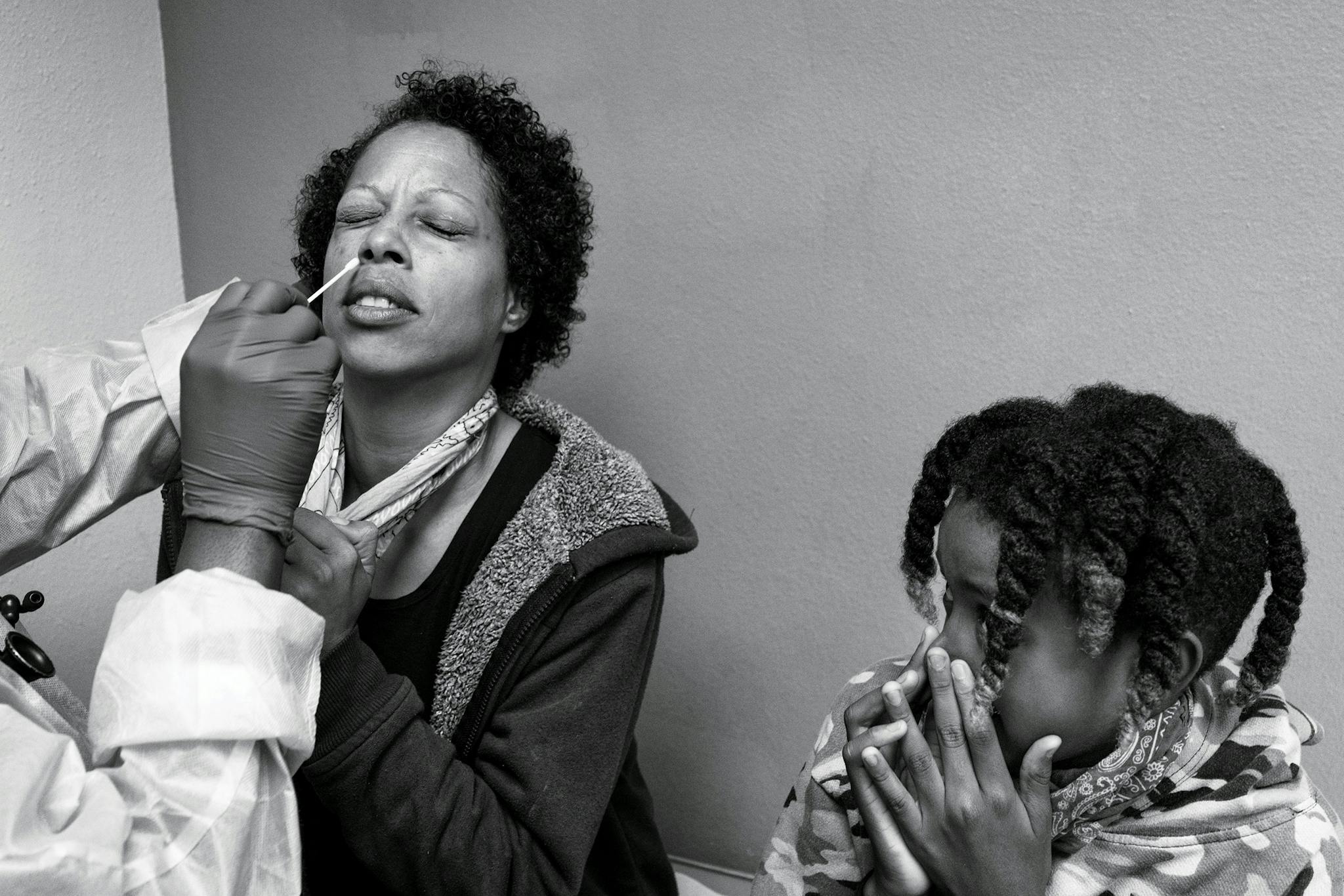 Ante Lewis, 11, watches his mother, Darline, 42, as she gets tested for COVID-19.