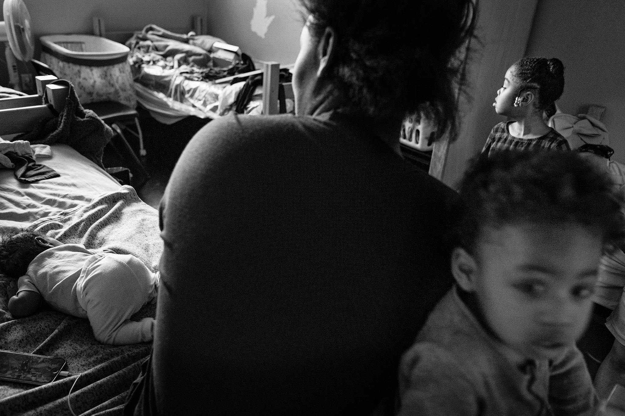 Whitney Bryant sits in her room at a shelter with three of her children—Kadyn, 6, Kasir, 2, and Khali, an infant—in February 2020.