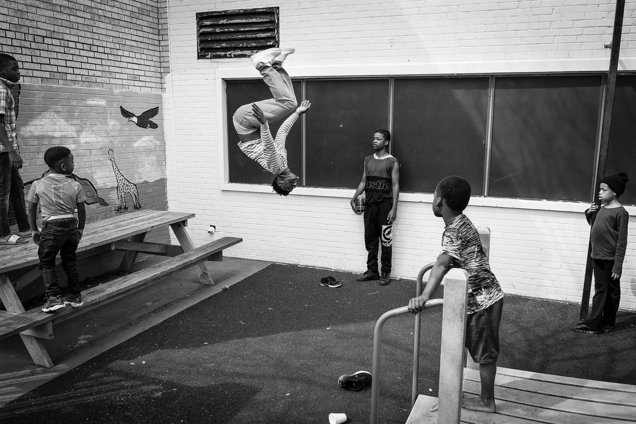 Dre, seventeen, does a backflip on the playground of Family Gateway’s shelter in February 2020.