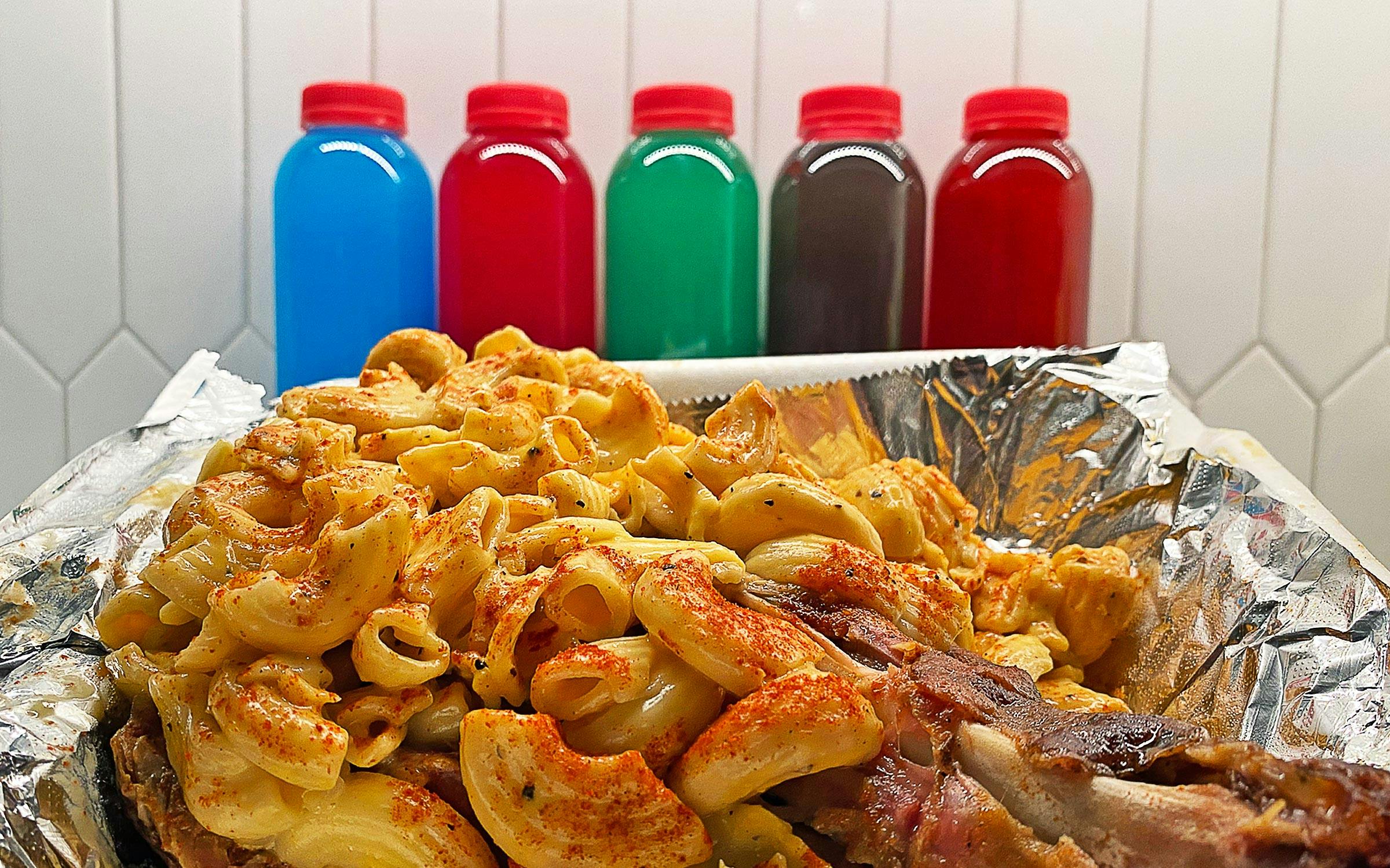 Seasoned mac and cheese and turkey in front of colorful bottled drinks. 