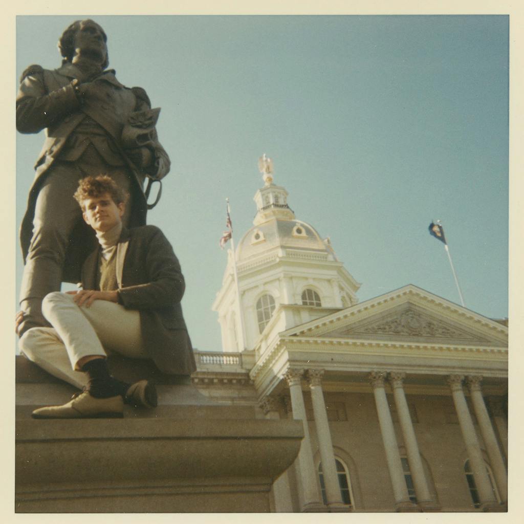 John Erickson poses with a statue at Harvard. 