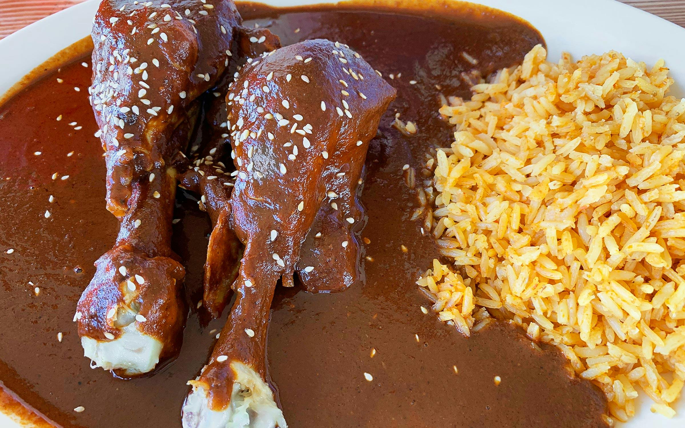 Chicken drumsticks in mole with a side of Mexican rice. 