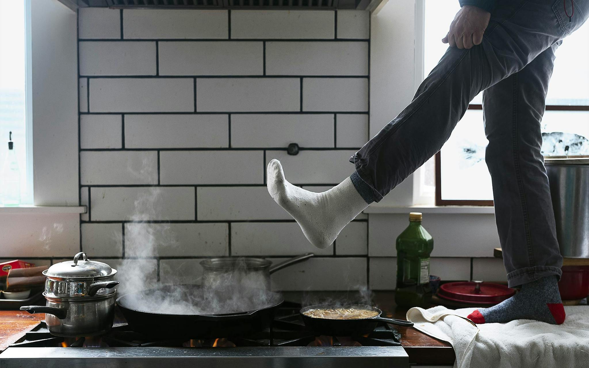 Austin citizen warming his feet over a gas stove during the 2021 Texas snow storm.