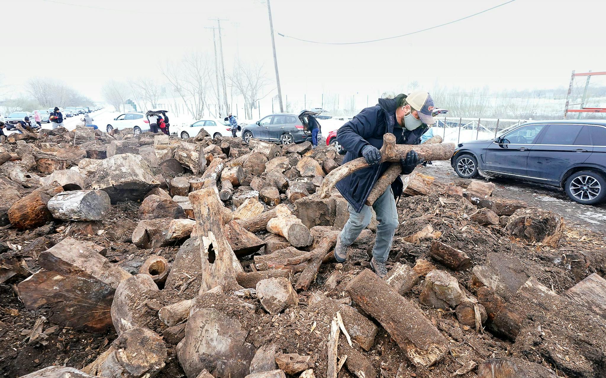 People in Dallas collecting firewood from a heap during the 2021 Texas snow storm.